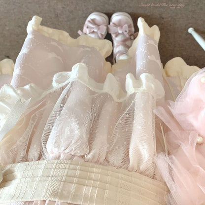 Pink and white dress with matching shoes on a neutral background
