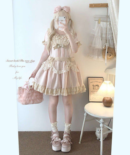 Person wearing a pastel pink outfit with a matching handbag in a room.