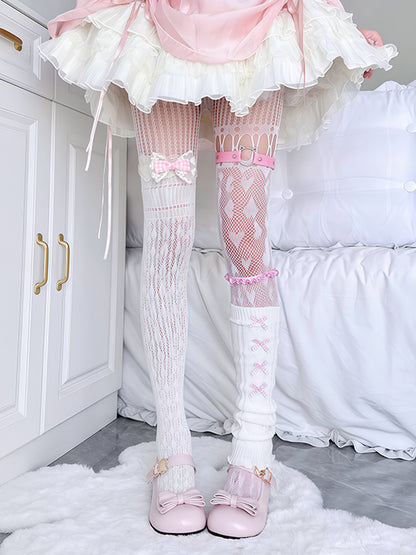 Person wearing a white dress with pink accents, white knee-high socks with pink bows, and pink shoes in a bedroom setting.