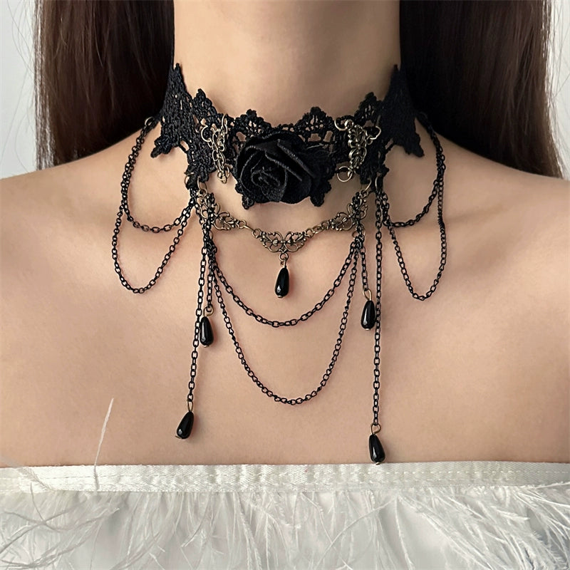 Black lace choker with chains and a black rose on a person's neck against a neutral background