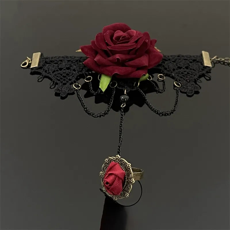 Black lace choker with red rose and matching ring on a dark background