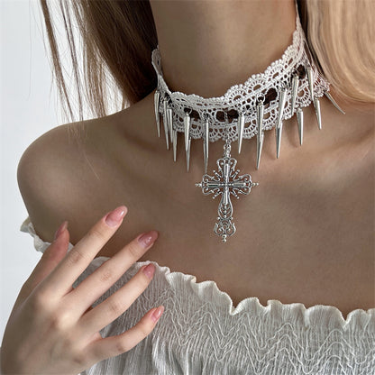 Person wearing a lace choker with spikes and a cross pendant on a plain background