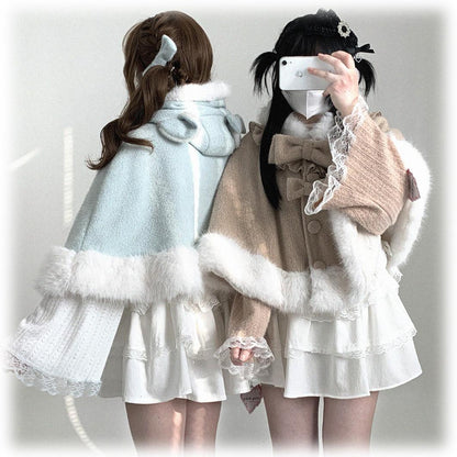 Two people wearing stylish outfits with capes and white dresses on a plain background