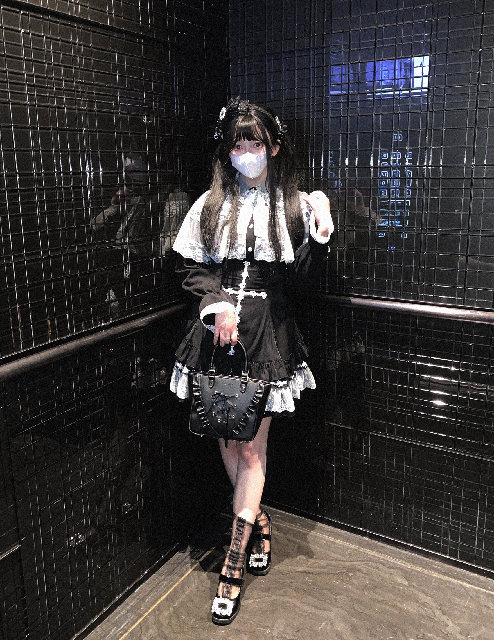 a woman wearing a white blouse and black high-waisted skirt with lace cross detailing and ruffle trim