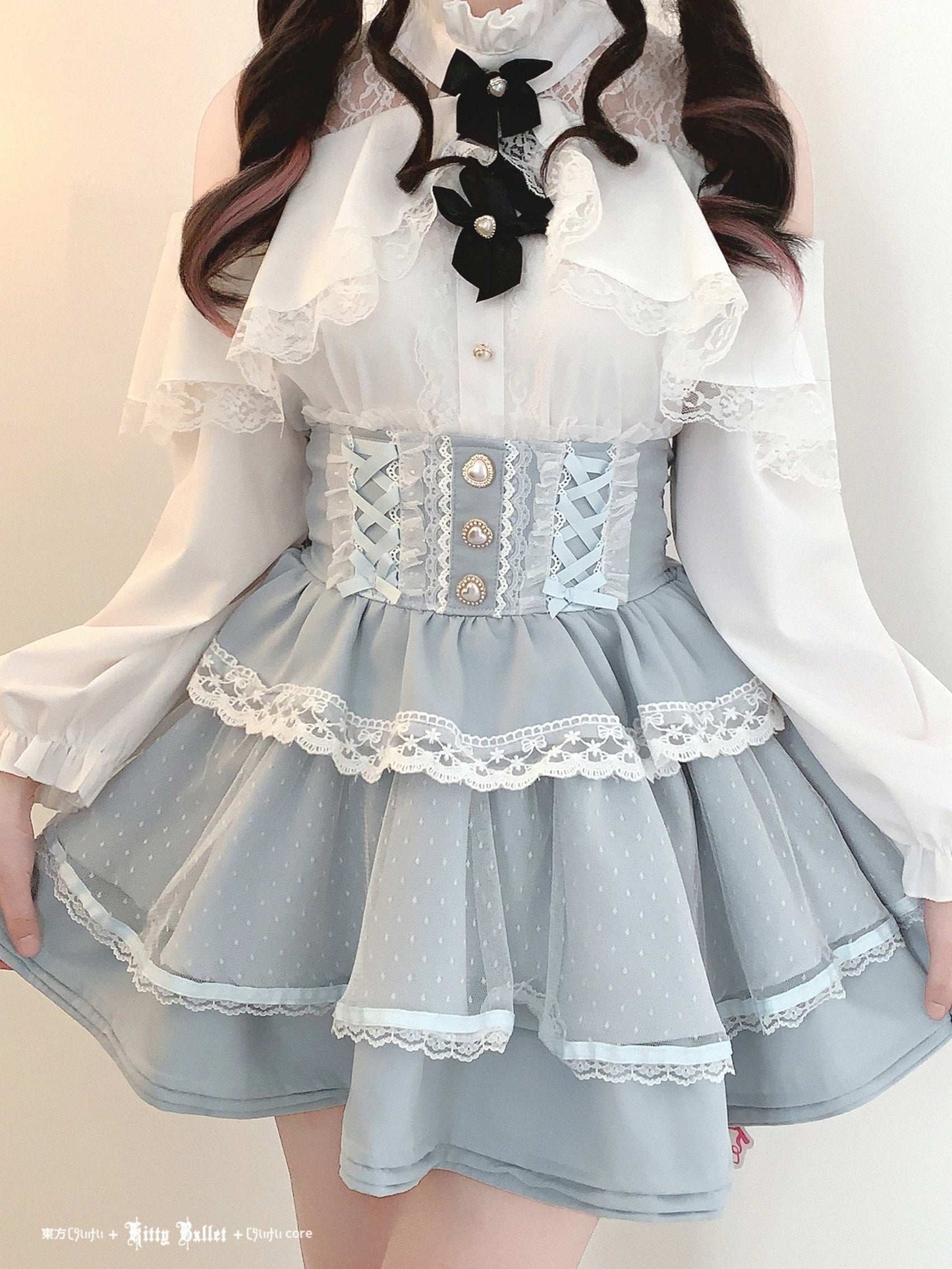 Person wearing a light blue dress with white lace details and a white blouse.