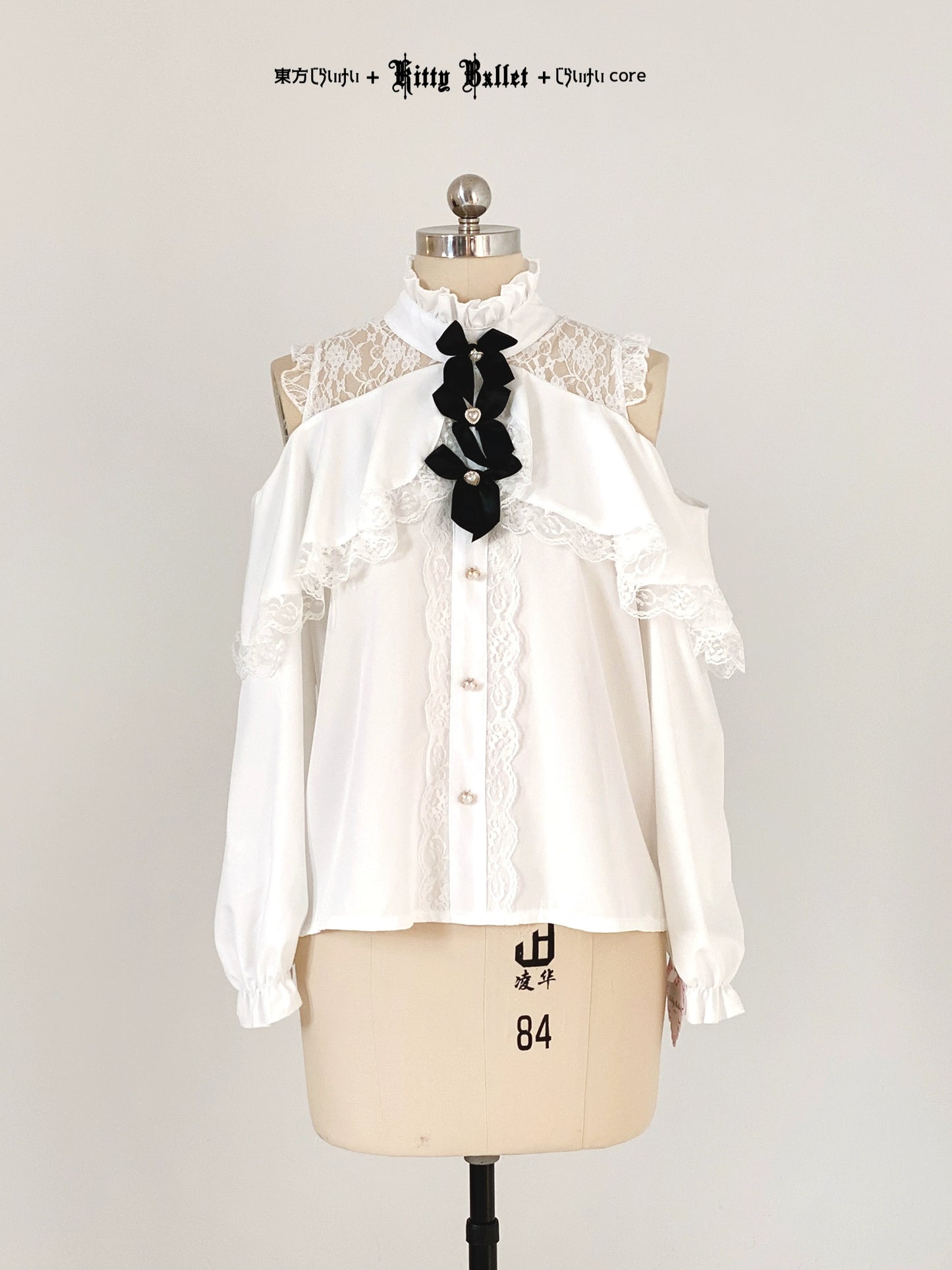 White blouse with black bow on a mannequin against a white background