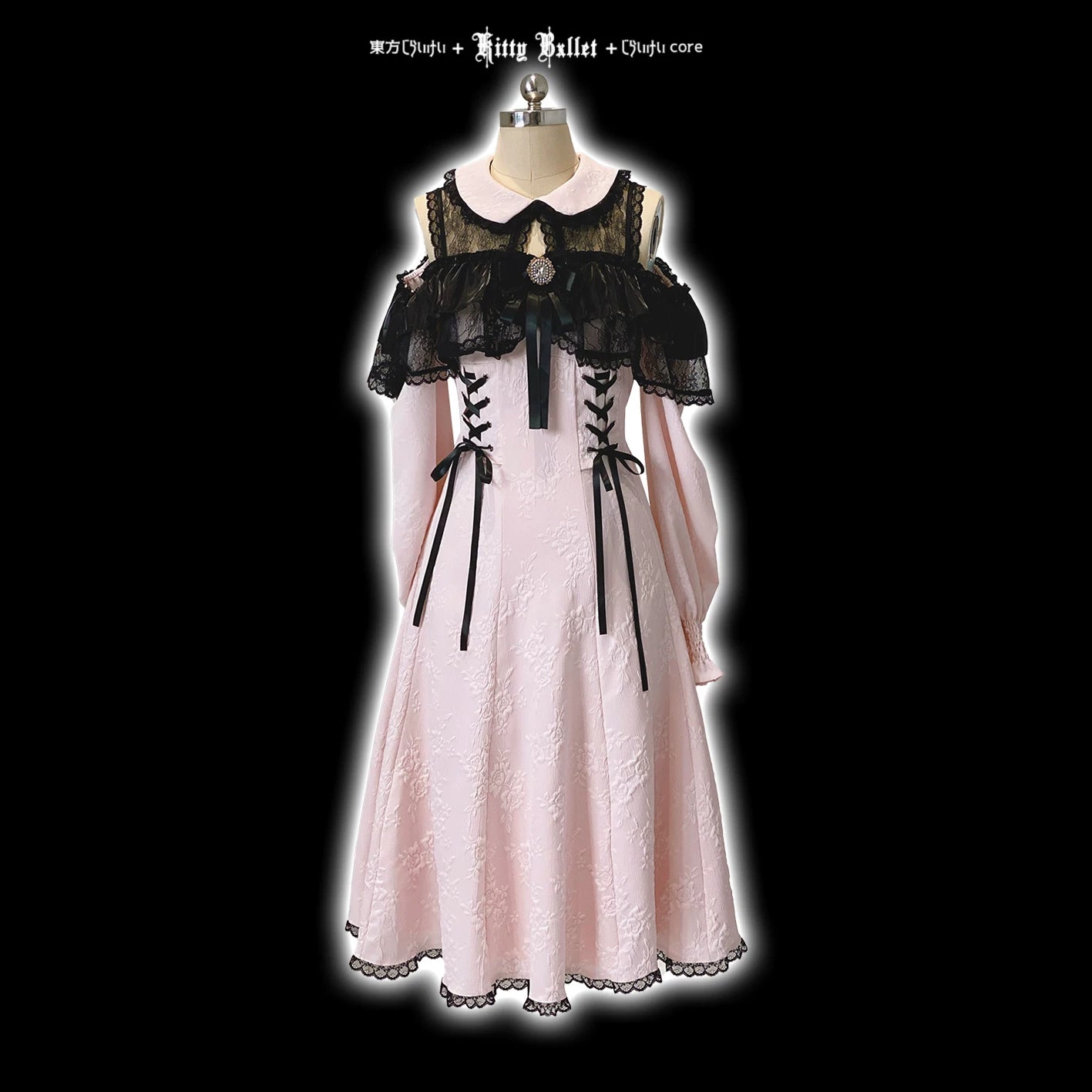 Pink dress with black lace details on a mannequin against a black background