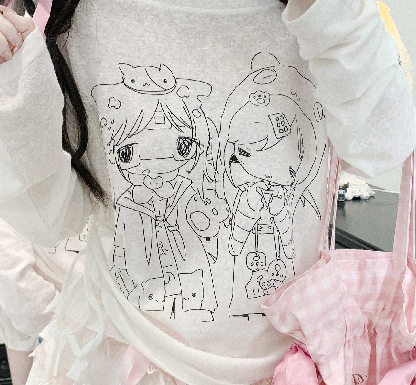 White sweatshirt with black line art of two cartoon characters on a white background.