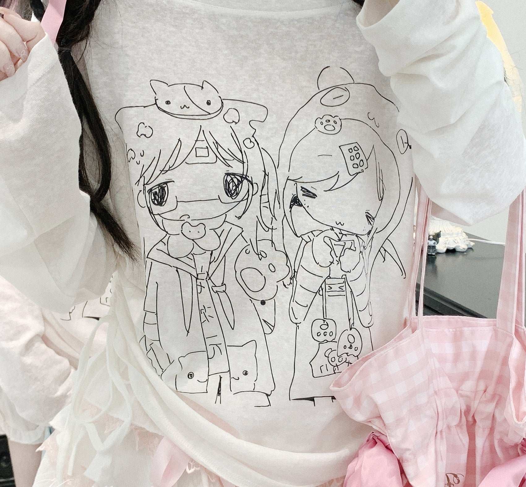 White sweatshirt with black line art of two cartoon characters on a white background.