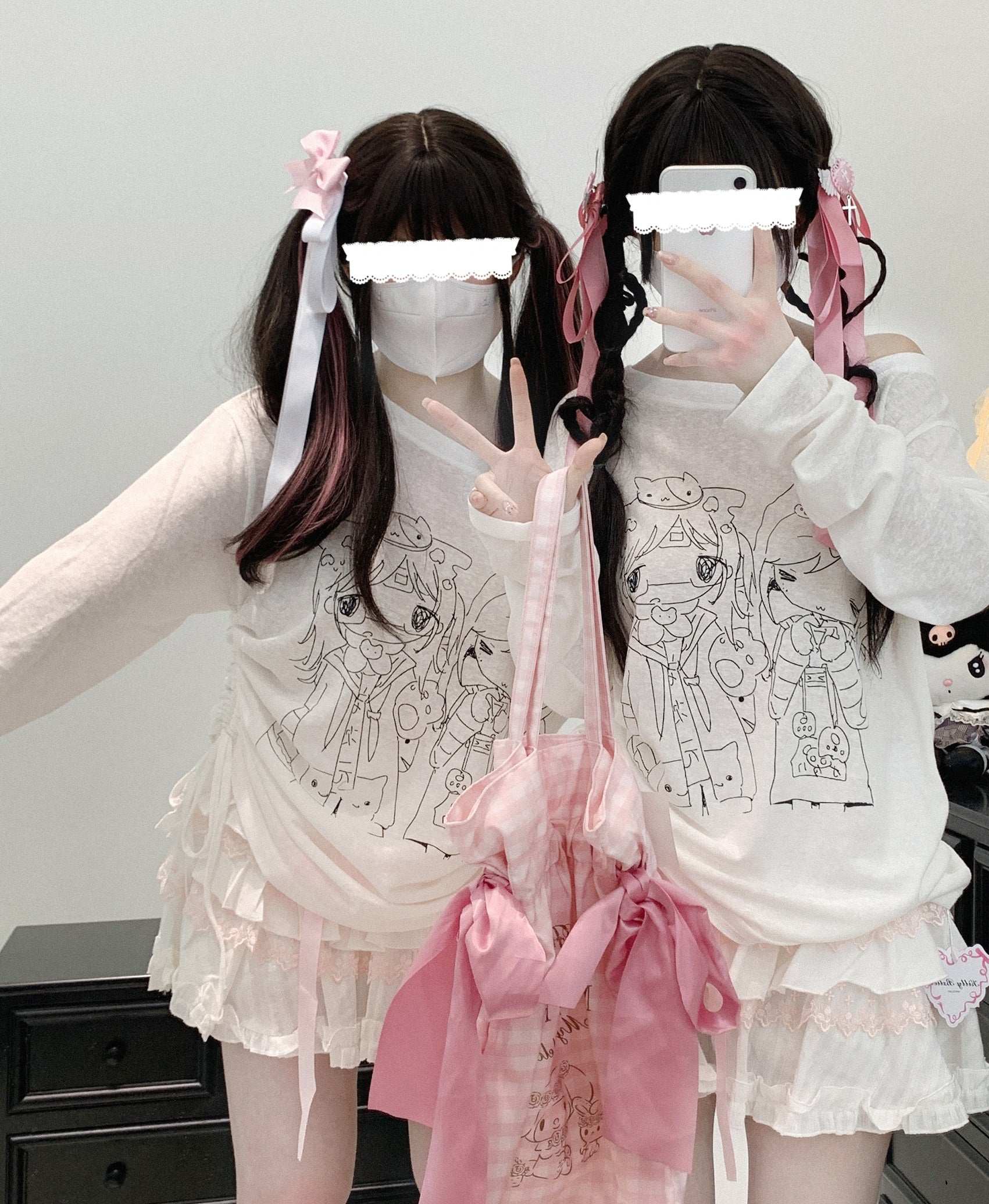 Two individuals wearing matching white off-shoulder sheer tops with flared sleeves and playful anime print.