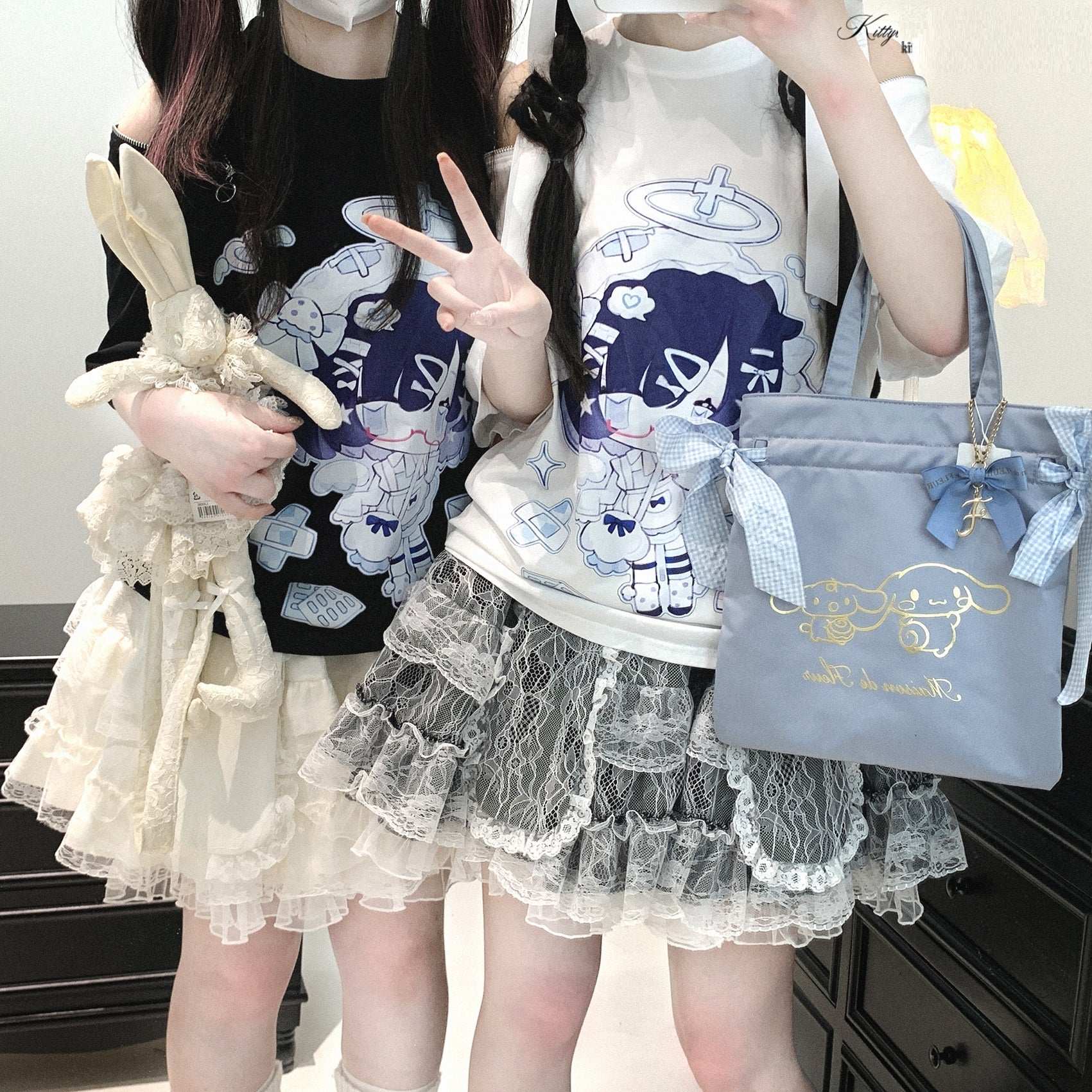 Two people wearing matching outfits with cartoon designs, one holding a plush toy and the other a handbag.