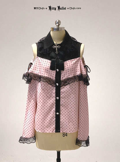 Pink polka dot blouse with black accents on a mannequin against a white background