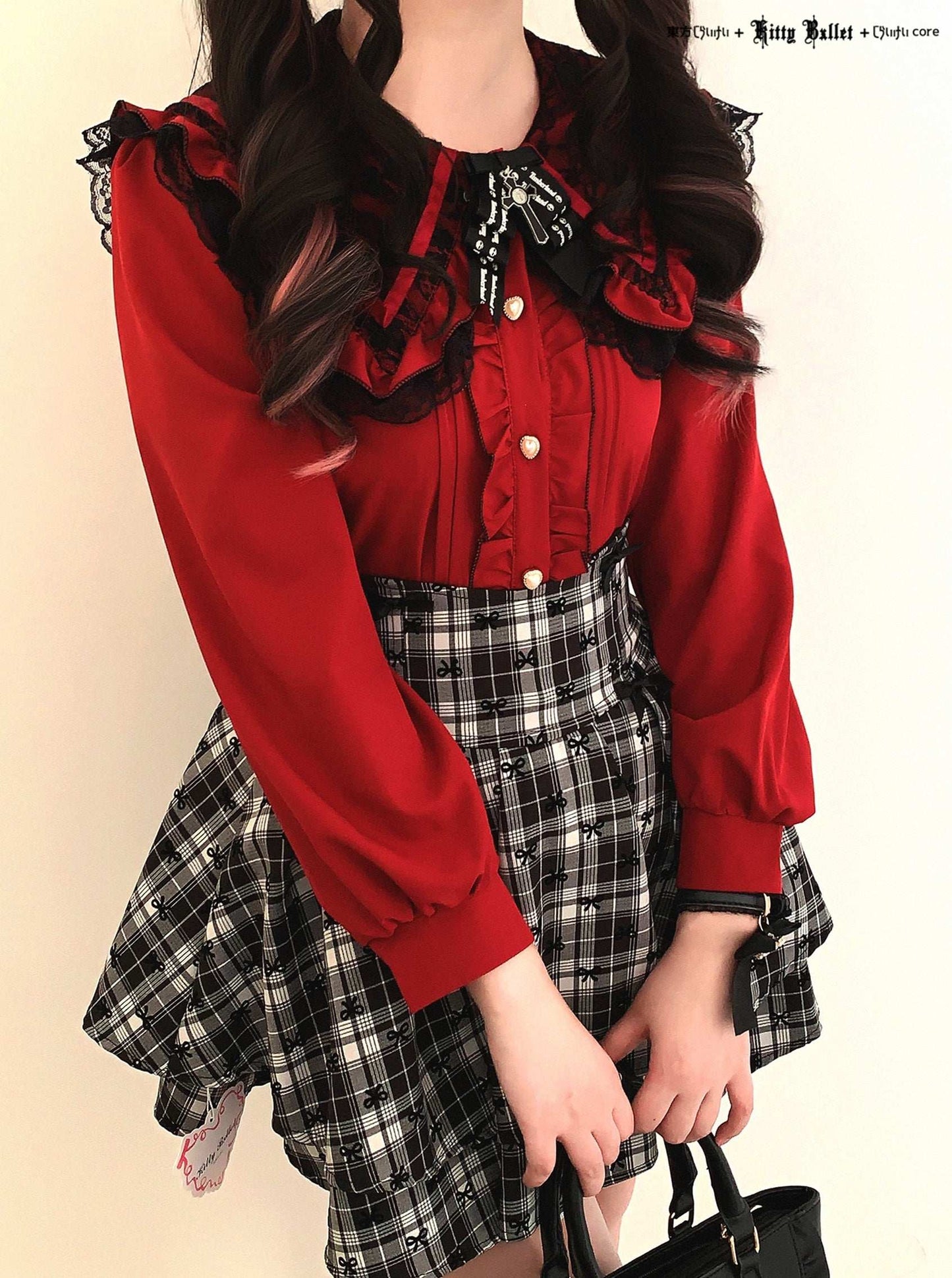 Person wearing a red blouse with ruffles and a plaid skirt against a beige background