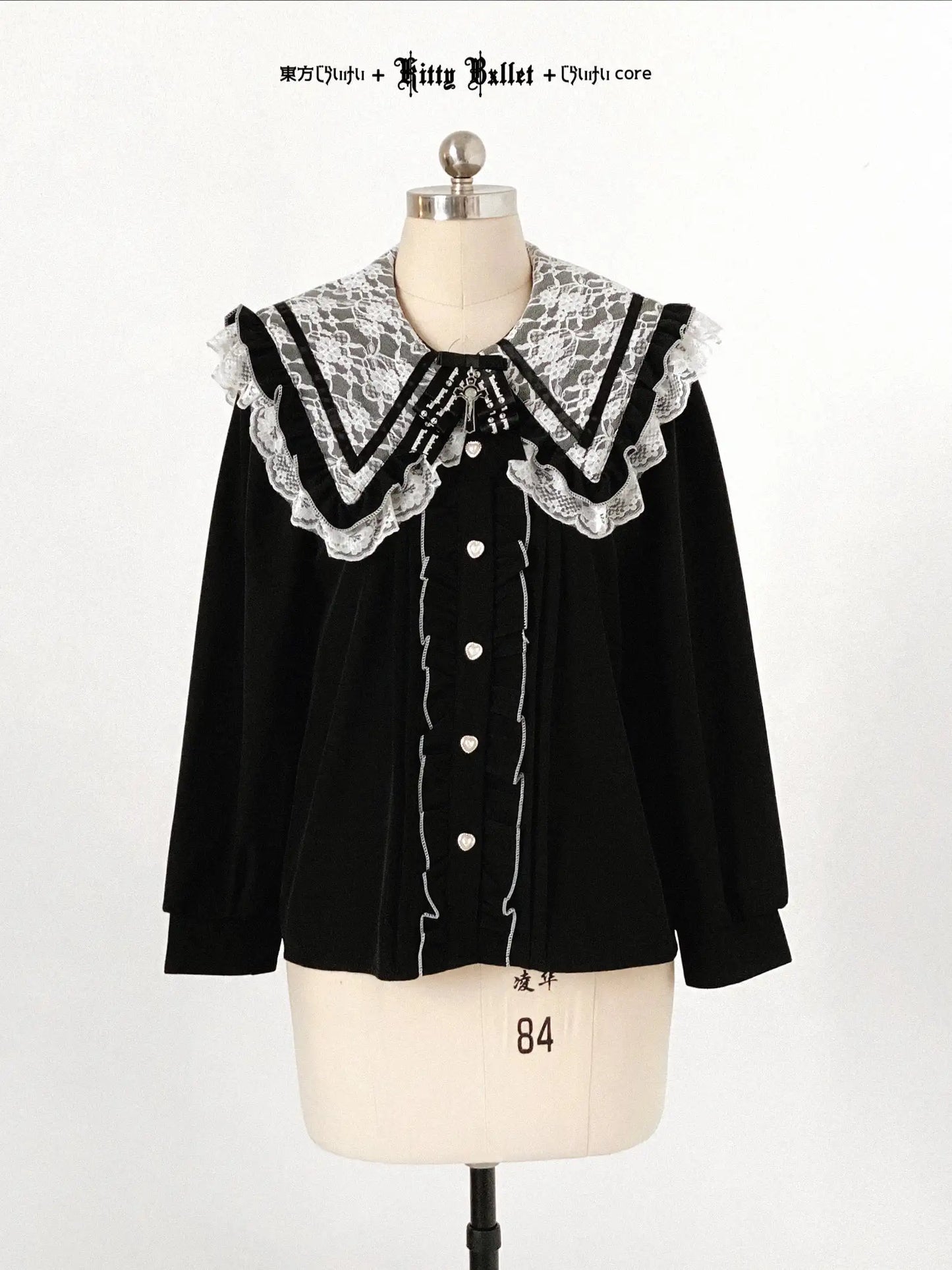 Black blouse with lace collar on a mannequin against a white background