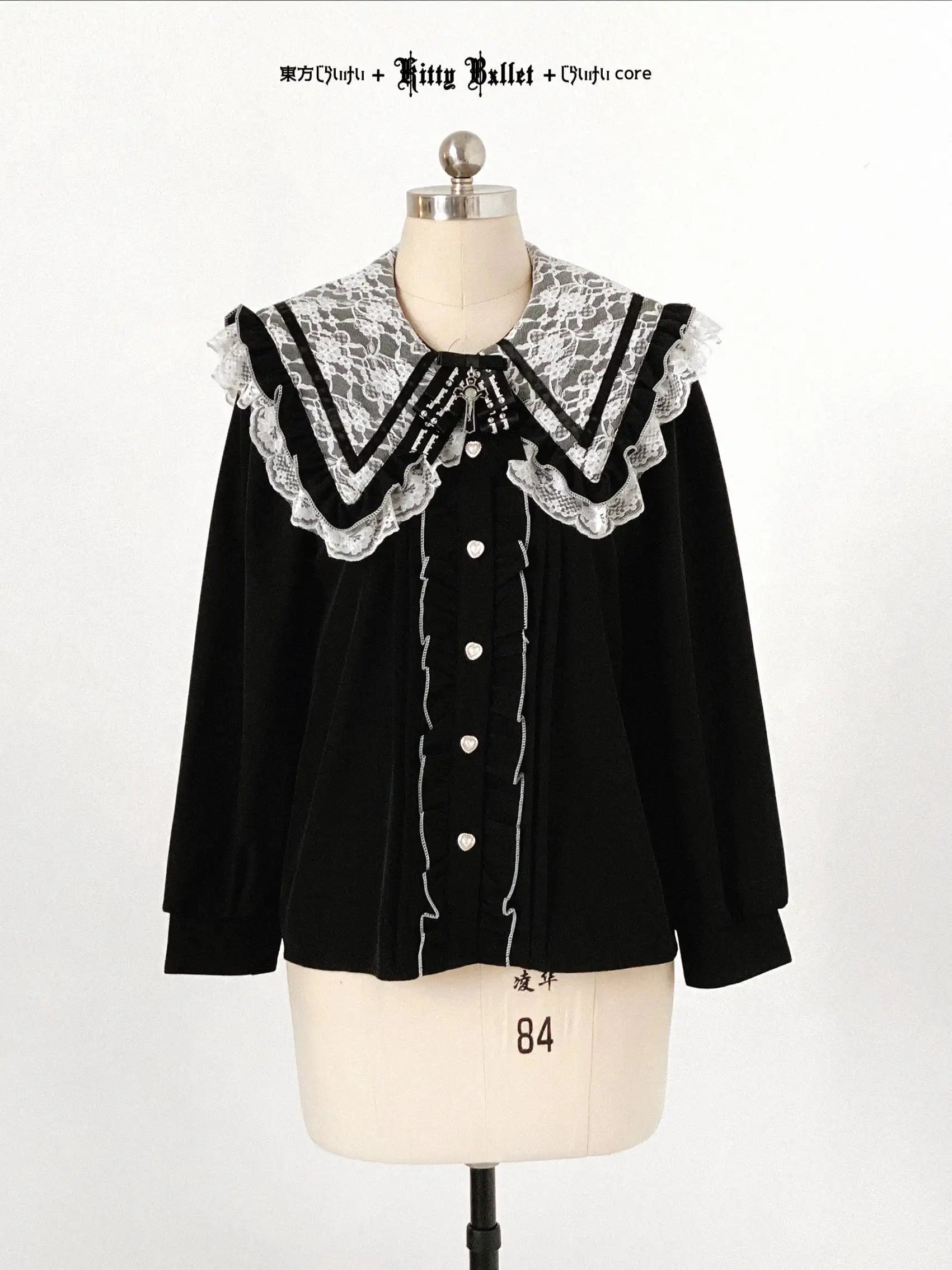 Black blouse with lace collar on a mannequin against a white background