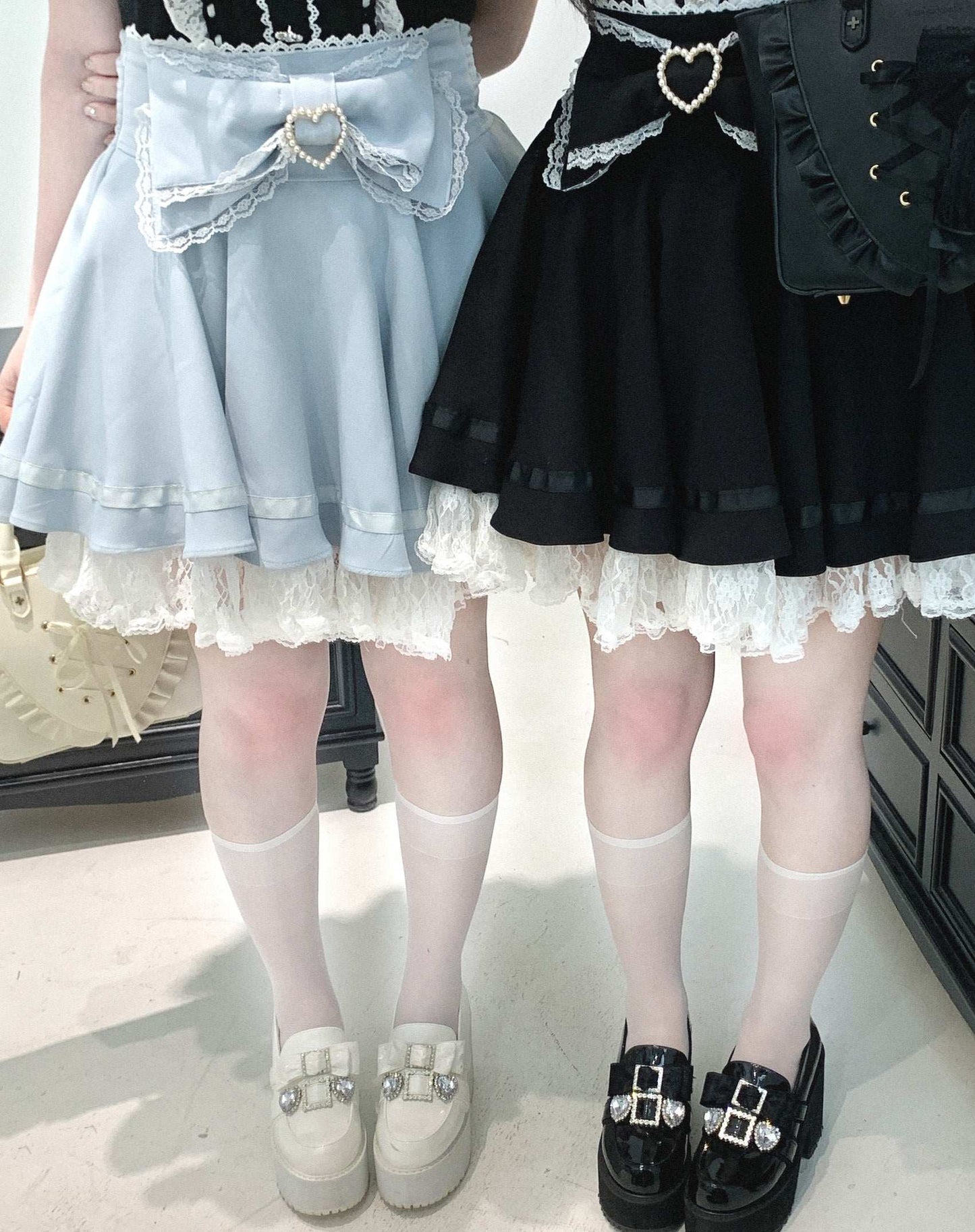 Two skirts, one light blue and one black, worn by models on a plain background.