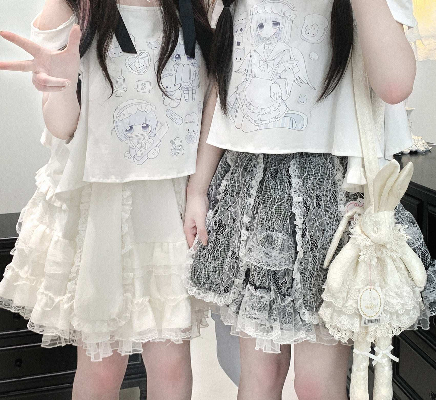 Two people wearing white tops with embroidered designs and lace skirts, holding a small bag.