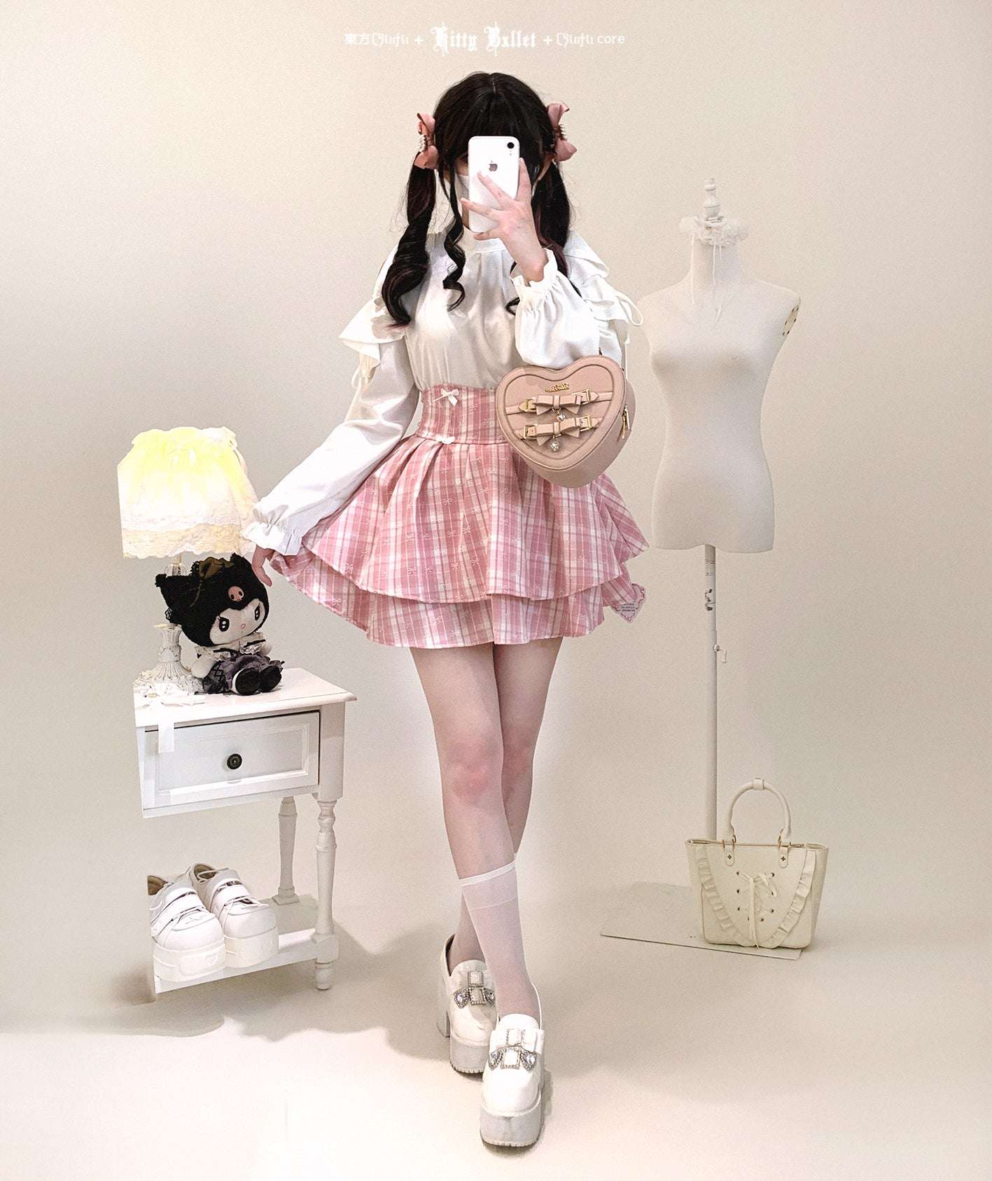 Person wearing a cute outfit with a white shirt, pink skirt, and white shoes in a studio setting.