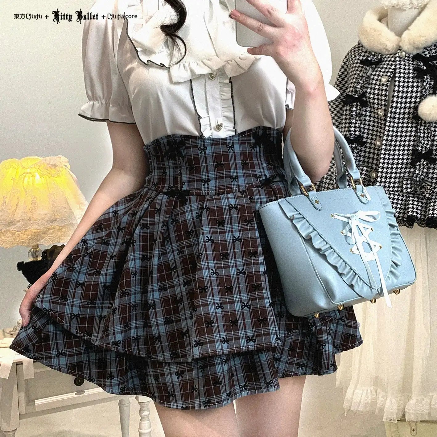 Person wearing a white blouse and plaid skirt with a blue handbag, standing in a room.