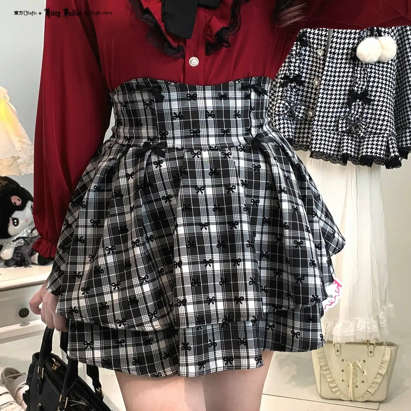 Person wearing a red top and black and white checkered skirt with bow pattern.