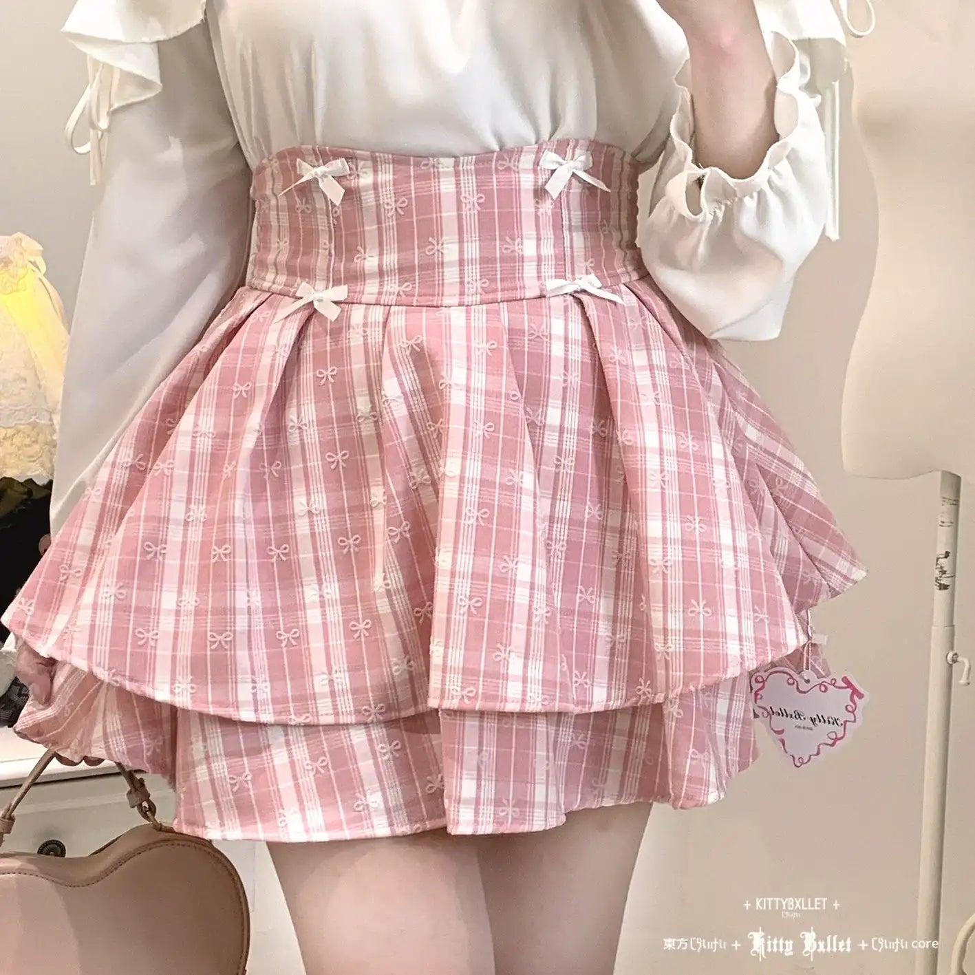 Person wearing a pink plaid skirt with a white blouse in a neutral setting