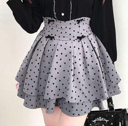 Gray skirt with black heart patterns worn by a person against a neutral background