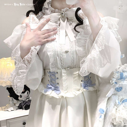 Person wearing a white ruffled outfit with decorative elements in jirai kei style, holding a plush toy.