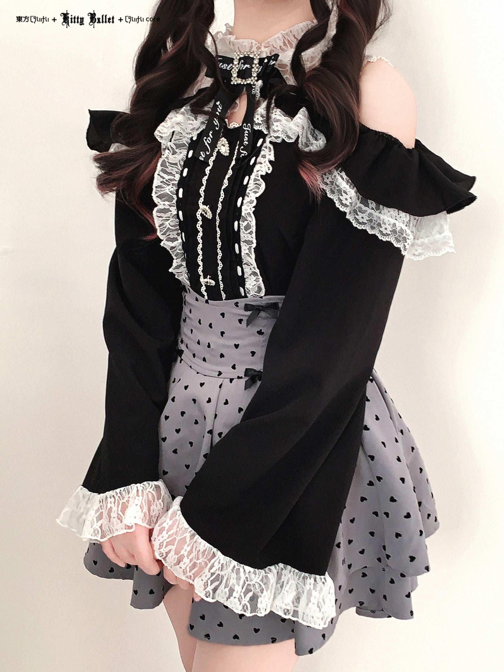 Black and white outfit with lace details in jirai kei style on a plain background