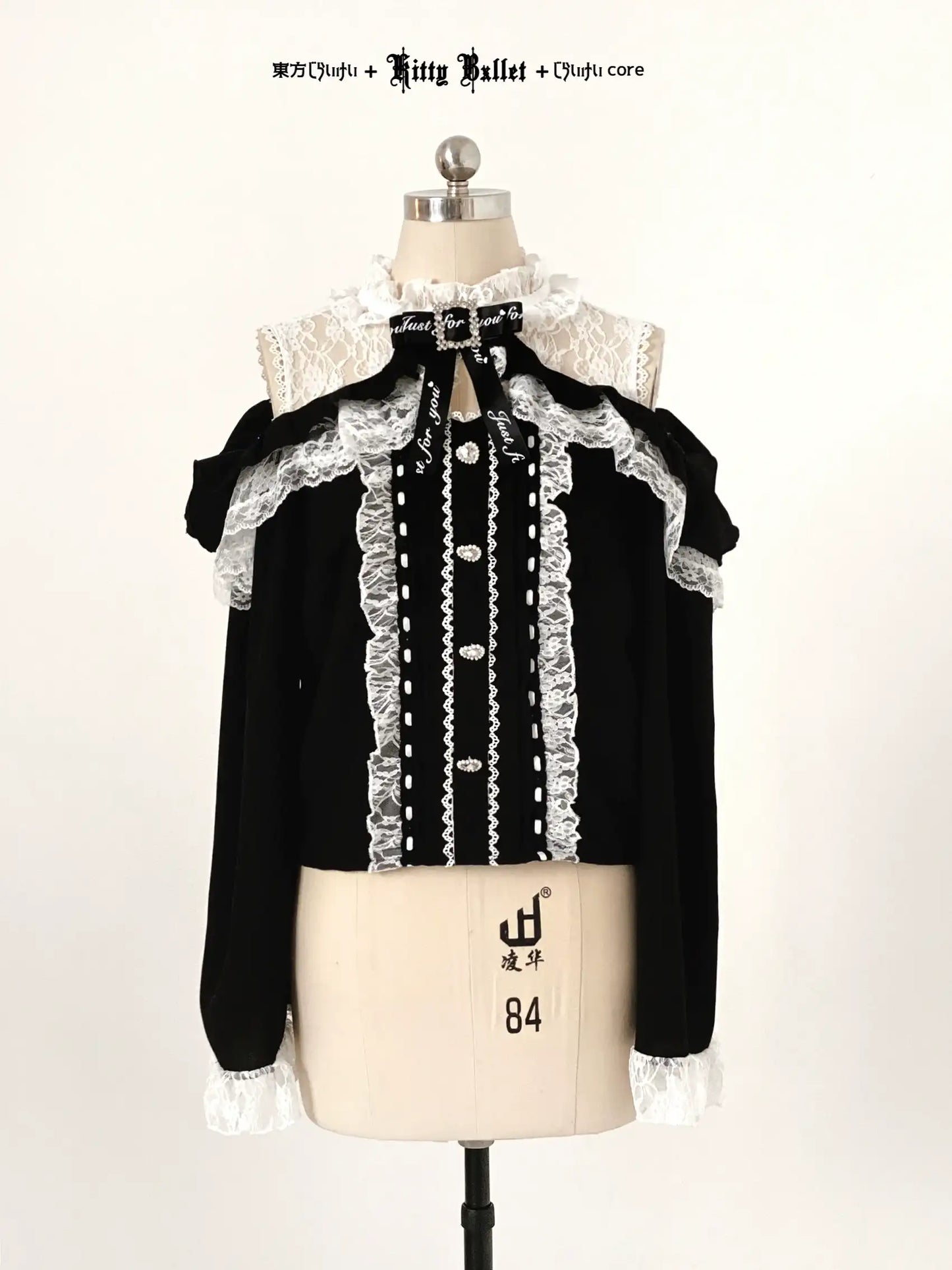 Black blouse with white lace details in jirai kei style on a mannequin against a white background