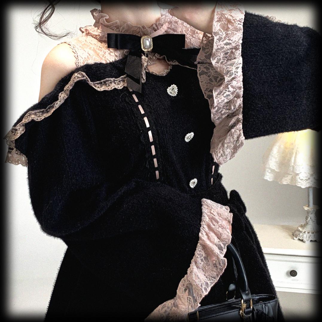 Black outfit with lace details and a handbag on a neutral background