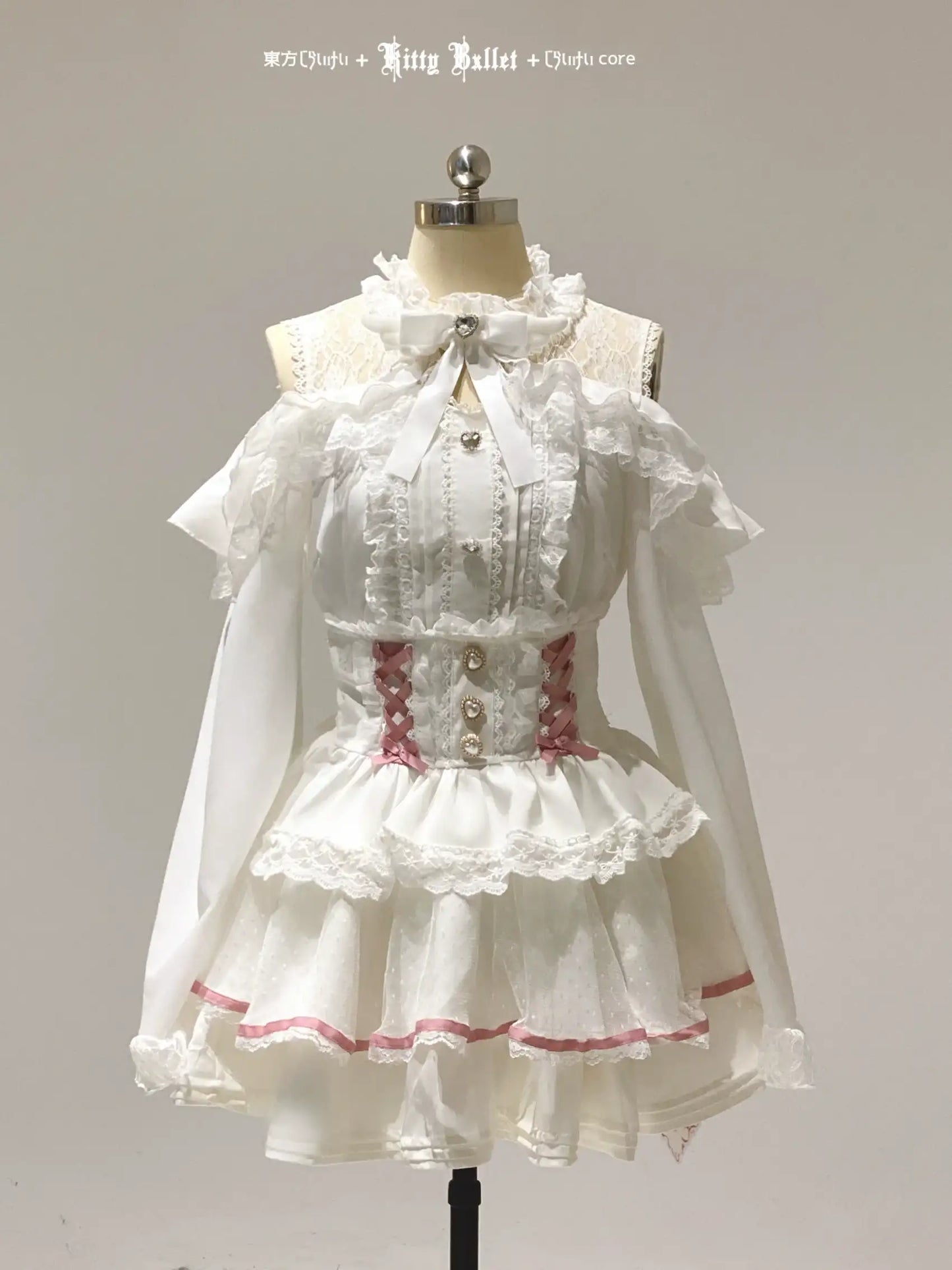 White lace jirai kei dress with red trim on a mannequin against a gray background