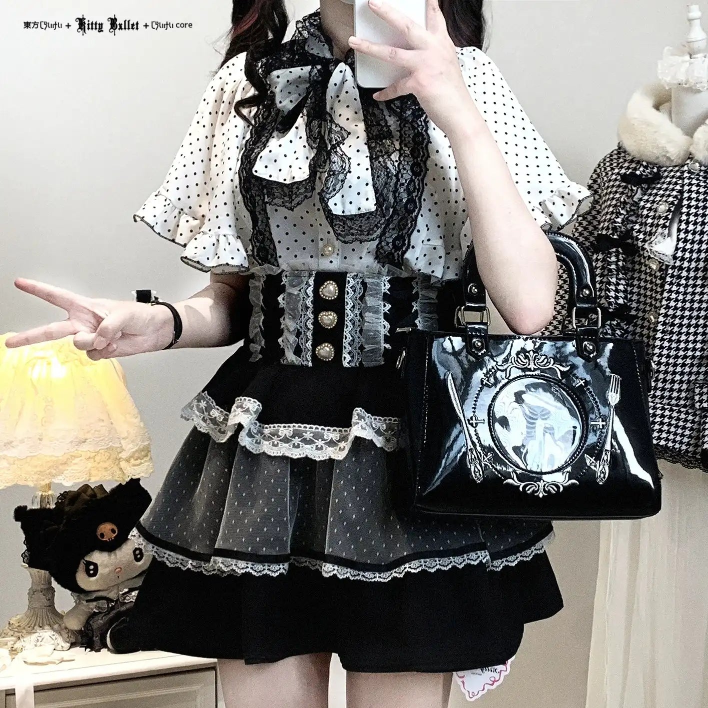 Person wearing a jirai kei black and white polka dot dress with a lace collar, holding a matching handbag.