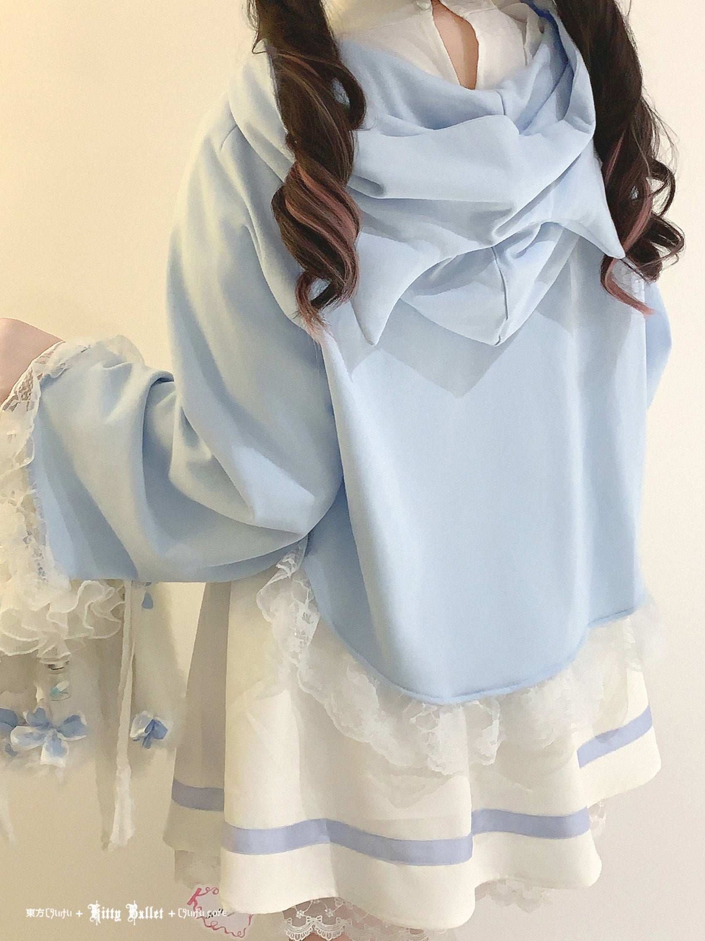 Person wearing a light blue scarf with a white dress