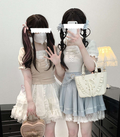 Two individuals in cute outfits with ruffled dresses and handbags, standing against a plain background.