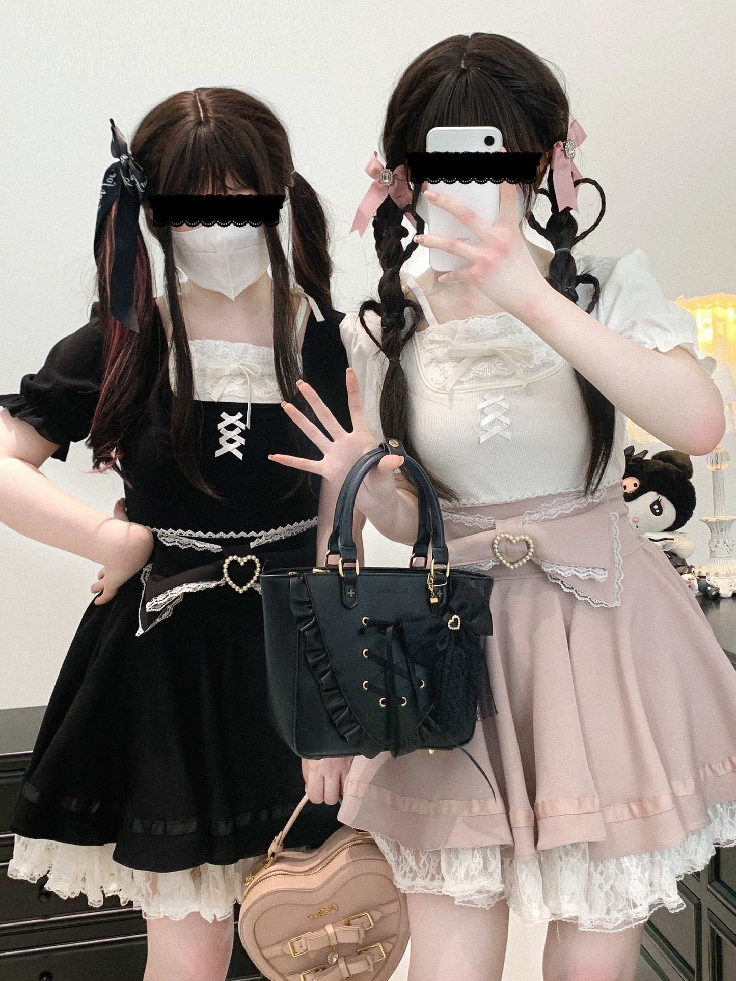 Two individuals in Lolita fashion outfits with handbags.