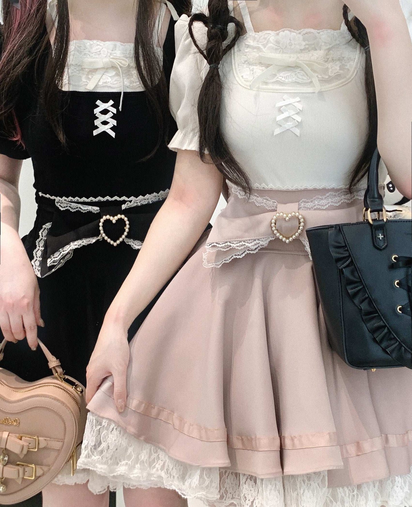 Two people wearing matching outfits with lace details and handbags.