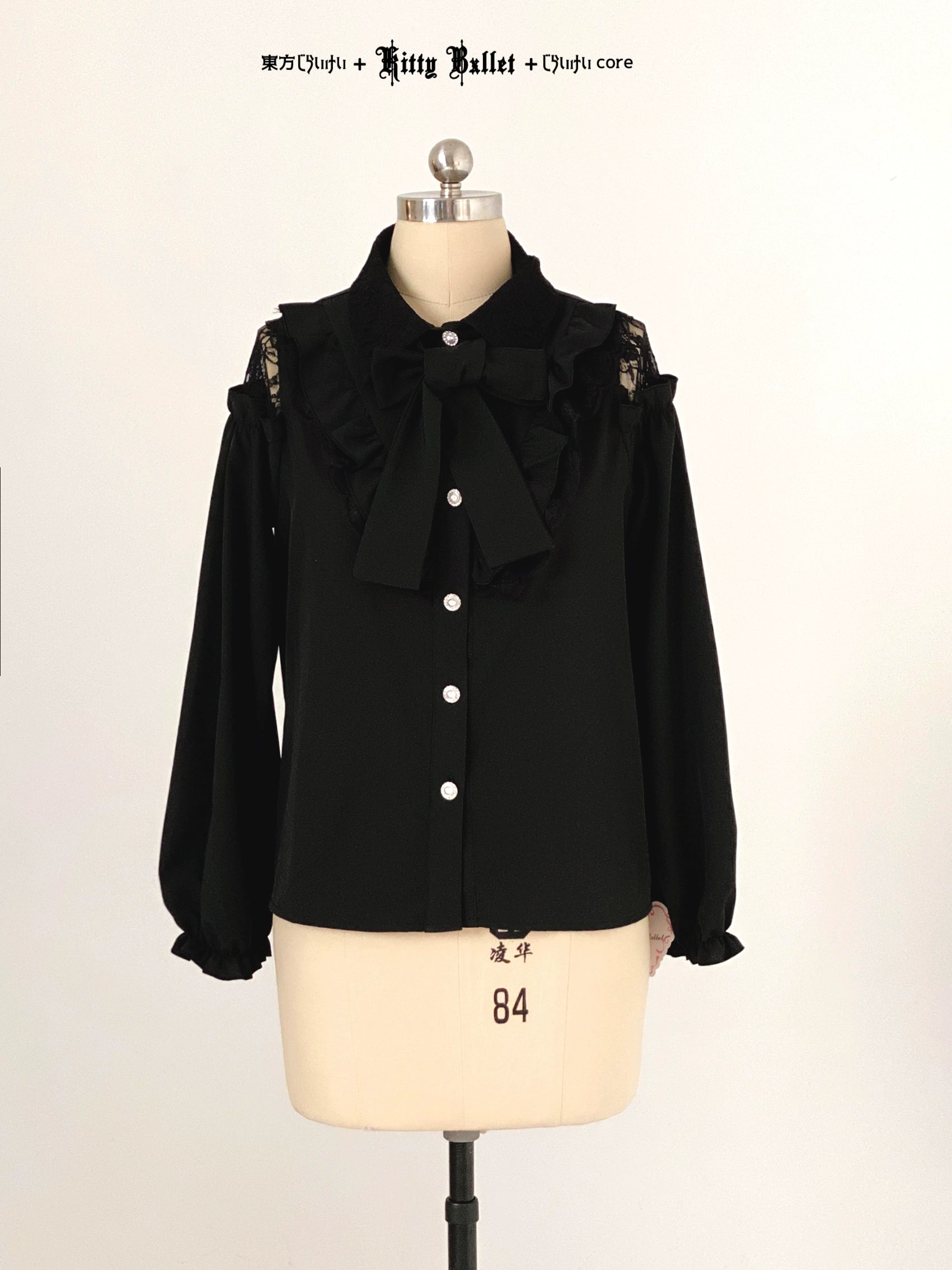 Black jirai kei blouse with ruffled collar on a mannequin against a white background