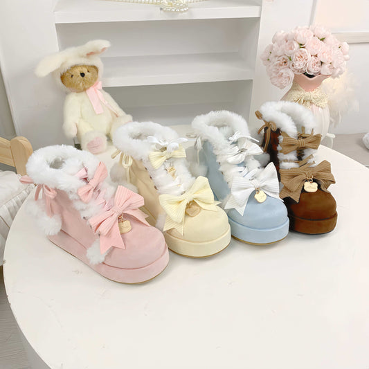 Set of pastel-colored children's boots with fluffy tops on a white surface.