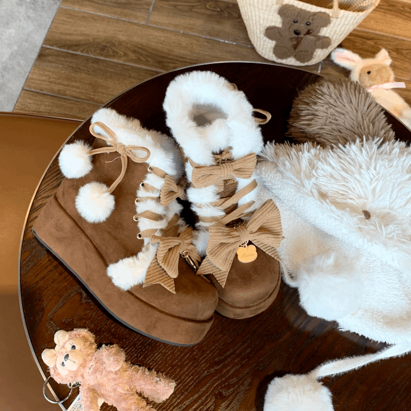 Pair of brown and white boots with bows on a wooden surface, surrounded by teddy bears and plush toys.