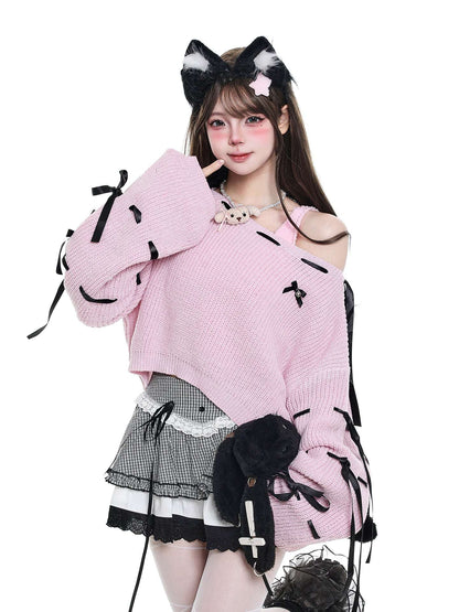 Person wearing a pink sweater with black details and a headband with cat ears on a white background