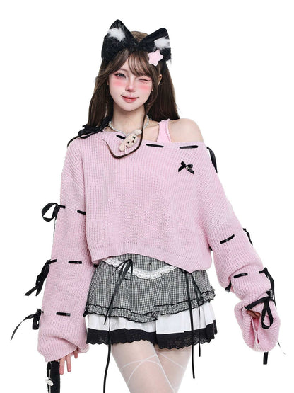 Person wearing a pink sweater with black ribbons and cat ears on a white background