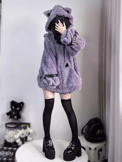 Person wearing a fluffy purple coat with a hood in a room setting.