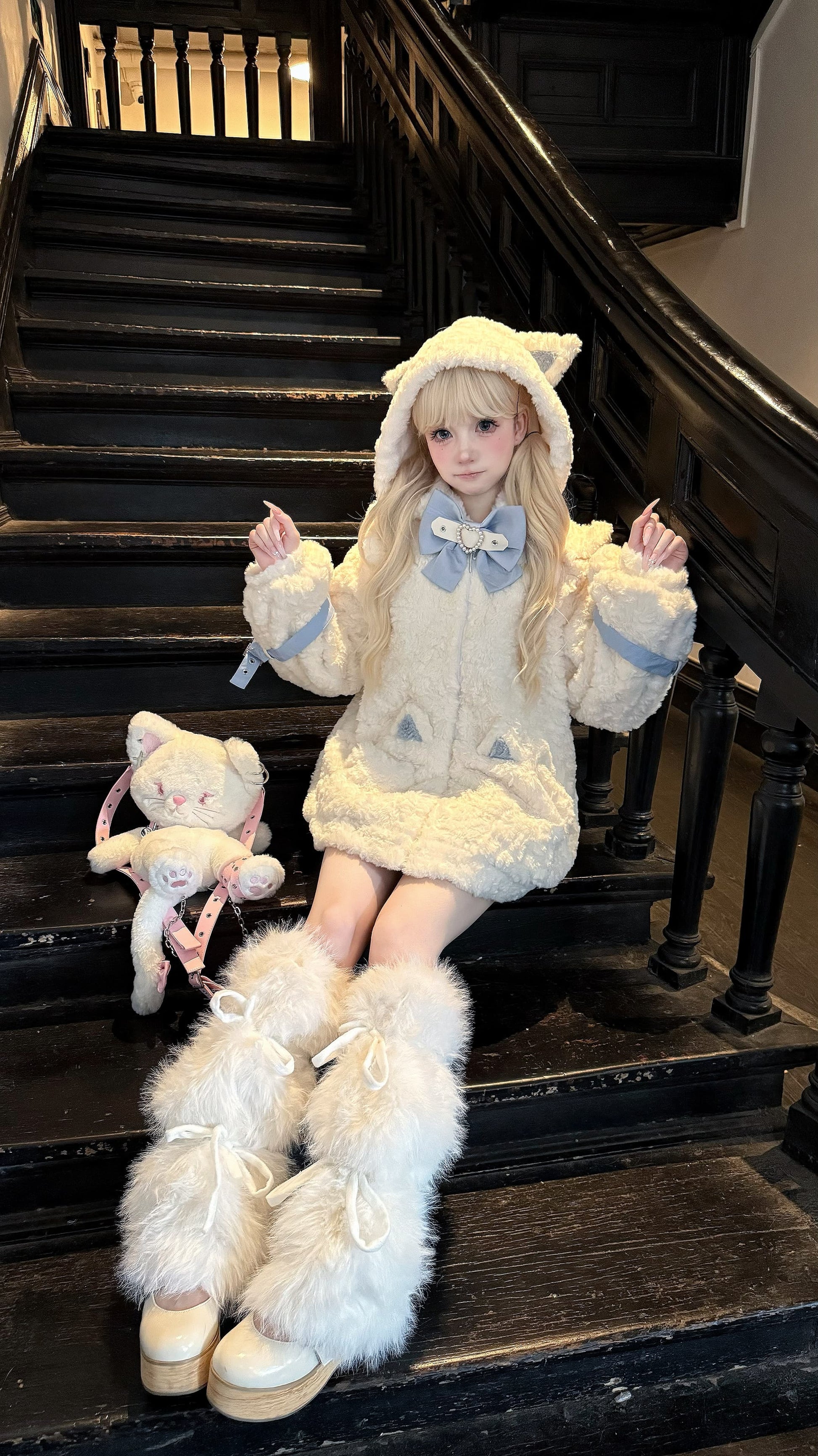 Person in a fluffy costume sitting on a staircase with a teddy bear.
