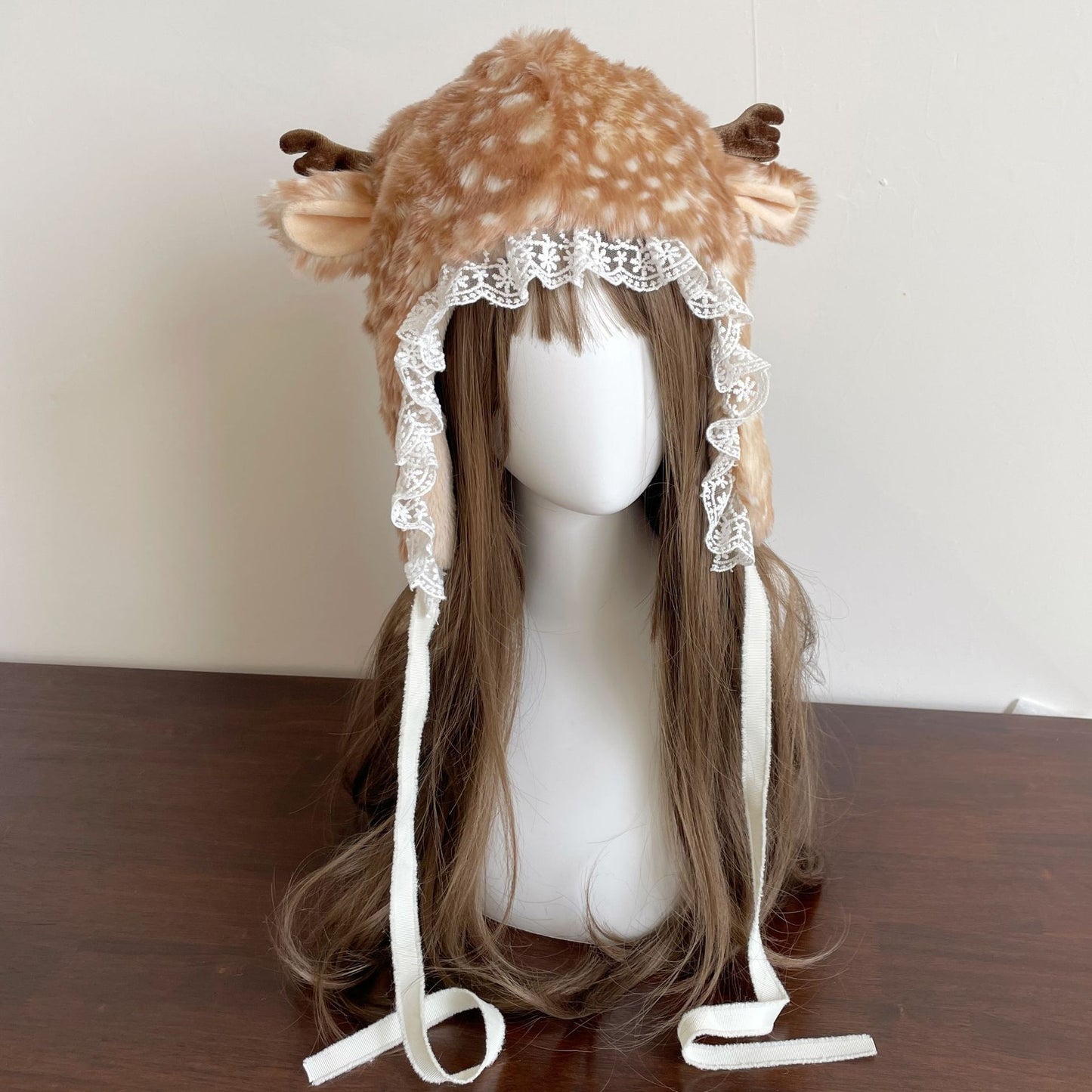 Deer-themed hat with antlers on a mannequin head against a plain background