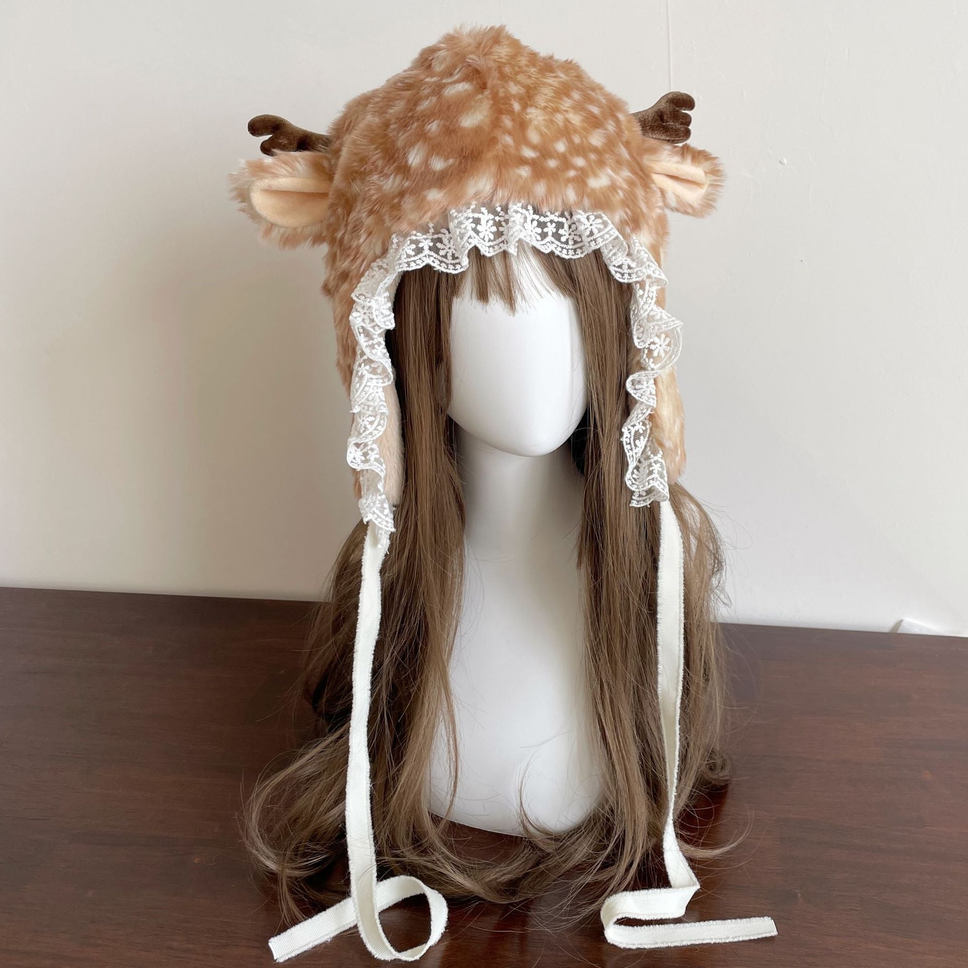 Deer-themed hat with antlers on a mannequin head against a plain background