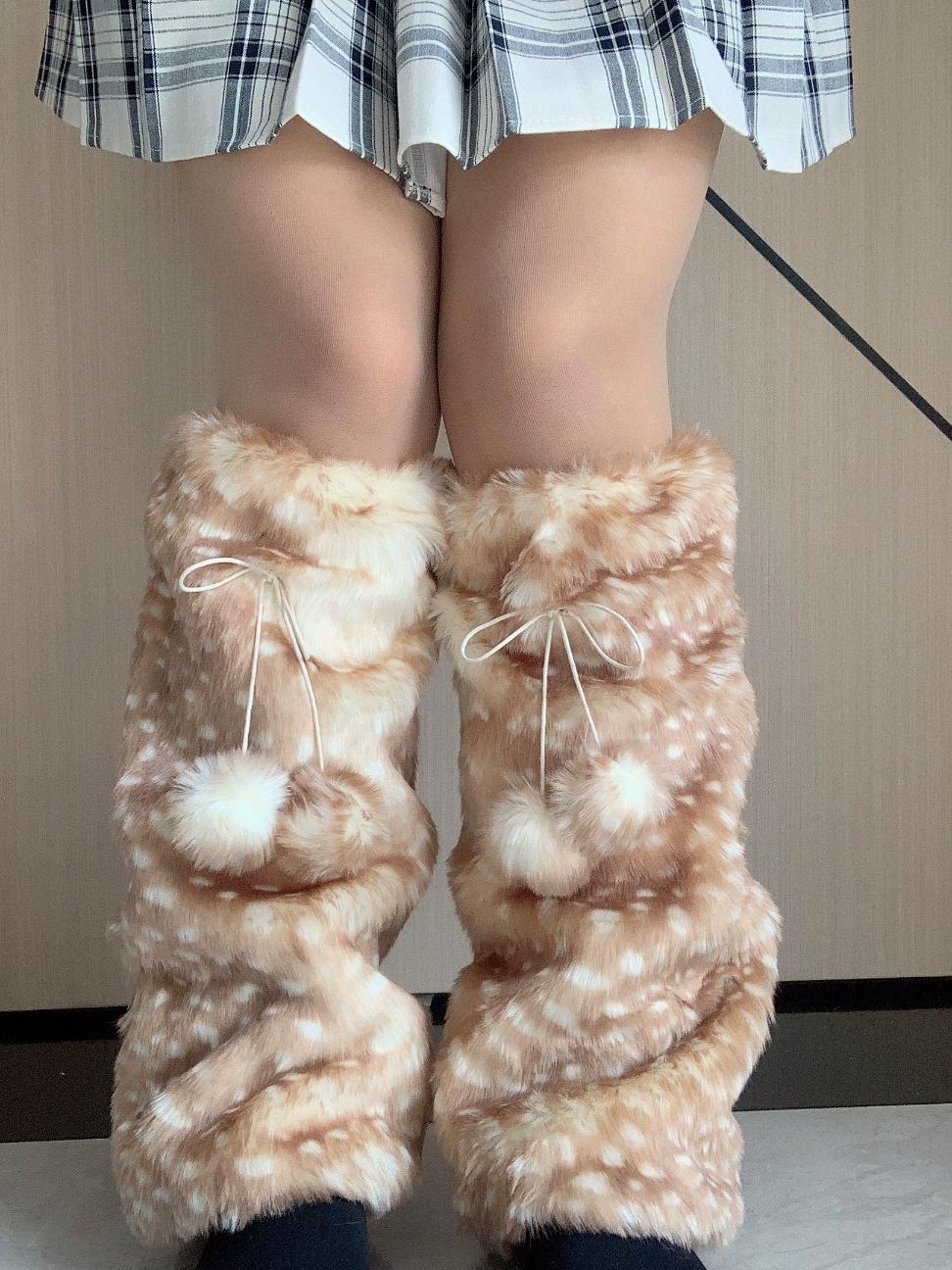 Furry knee-high boots with white polka dots worn by a person in a plaid skirt.