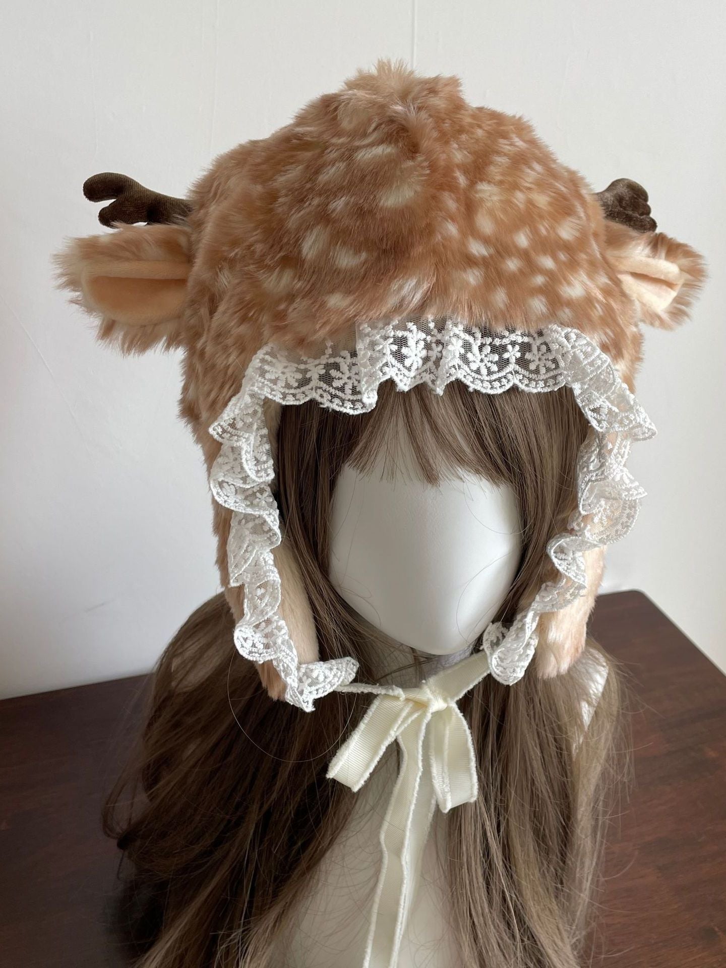 Deer hat with lace details on a mannequin head against a white background