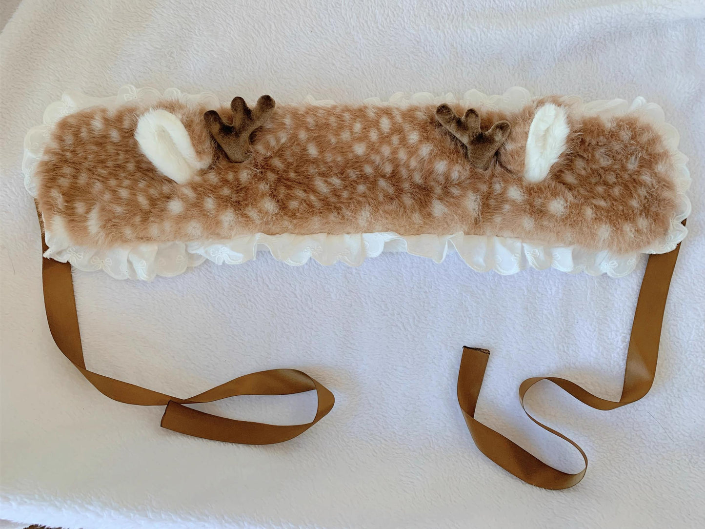 Faux fur headband with animal print and ribbons on a white background