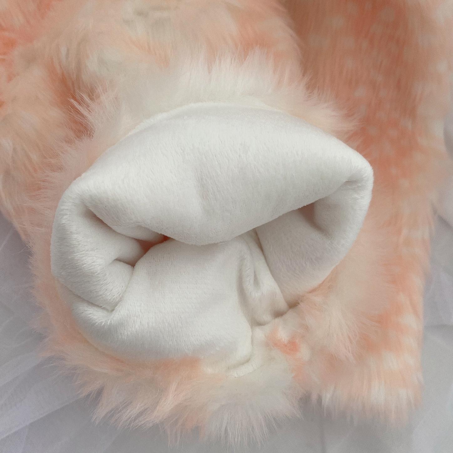 Close-up of a deer pattern pink leg warmers on a pink fluffy background