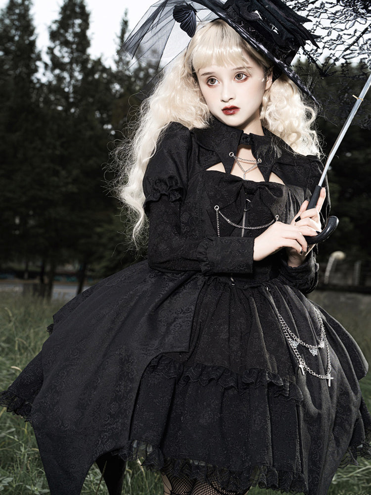 Person in a black gothic outfit with a parasol in an outdoor setting